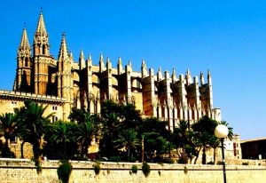 Palmas Kathedrale und die bezaubernde Altstadt Seit vielen Jahrhunderten ist dies der erste Eindruck, den Schiffsreisende haben, die sich der Inselhauptstadt auf dem  klassischen Wasserweg nähern. La Seu, wie die große Bischofskirche genannt wird, ist eine der schönsten mittelalterlichen Skralbauten Spaniens. Über 300 Jahre, ab 1230 nach der Eroberung durch die christlichen Festlandspanier, bauten die Palmesaner an dieser  ‘‘Kathedrale  des Lichts,., .  Es ist ein grandioses Schauspiel, wenn das Sonnenlicht  durch die riesige Rosette  und die 35 großen Bogenfenster fällt. Das von 14 schlanken Säulen getragene Hauptschiff wird mit geradezu unwirklichem Licht erfüllt, das einen reizvollen Kontrast zu den schattigen17 Nebenkapellen bildet. Einen Besuch ist das Museum in der Kathedrale wert. Prunkstück der Sammlung an Gemälden, Reliquien und Sakralgegenständen ist ein übermannshoher silberner Kandelaber aus feinem Silber. Umgeben ist die Kathedrale und Bischofsitz von der mittelalterlichen Altstadt. Neben zahlreichen Museen und Baudenkmälern ziehen die berühmten Patios, die künstlerisch gestalteten  Innenhöfe der Patrizierhäuser, viele Besucher an. Allerdings sind die meisten mittelalterlichen Kleinode nur an Ostern und Fronleichnam geöffnet. Einige erlauben den Einblick in ihr schattig-kühles Innenleben durch schmiedeeiserne Tore. Die Altstadt  von Palm de Mallorca ist das Zentrum des traditionellen Handwerks und Handels. Ideal für einen spontanen Shopping-Bummel.